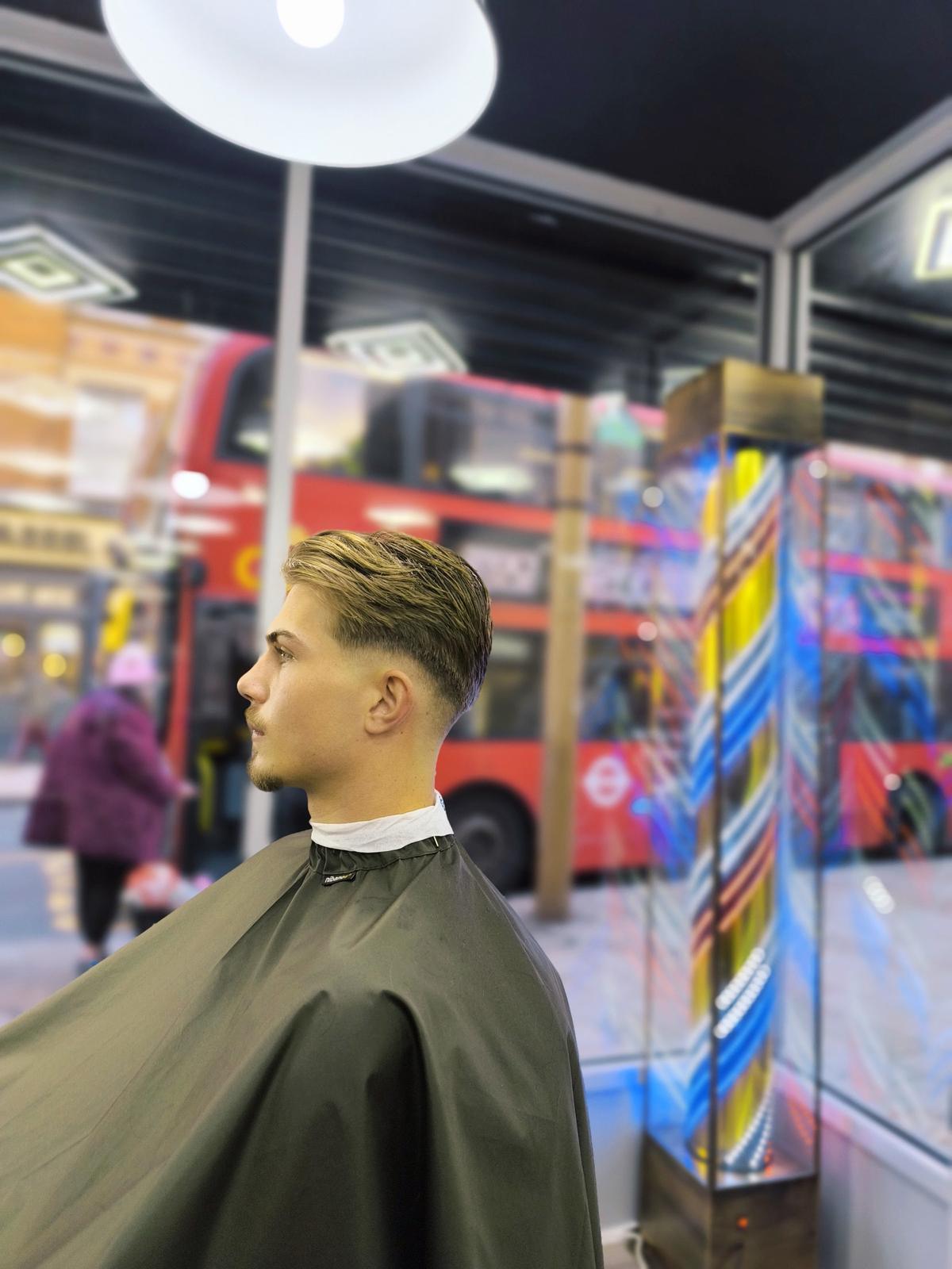 Close-up of a skin fade, with clippers at the side of the head
