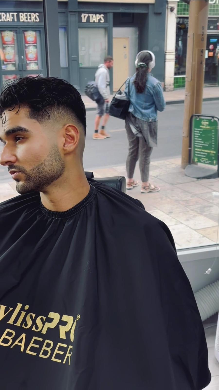 Customer in a barber chair with a short textured crop